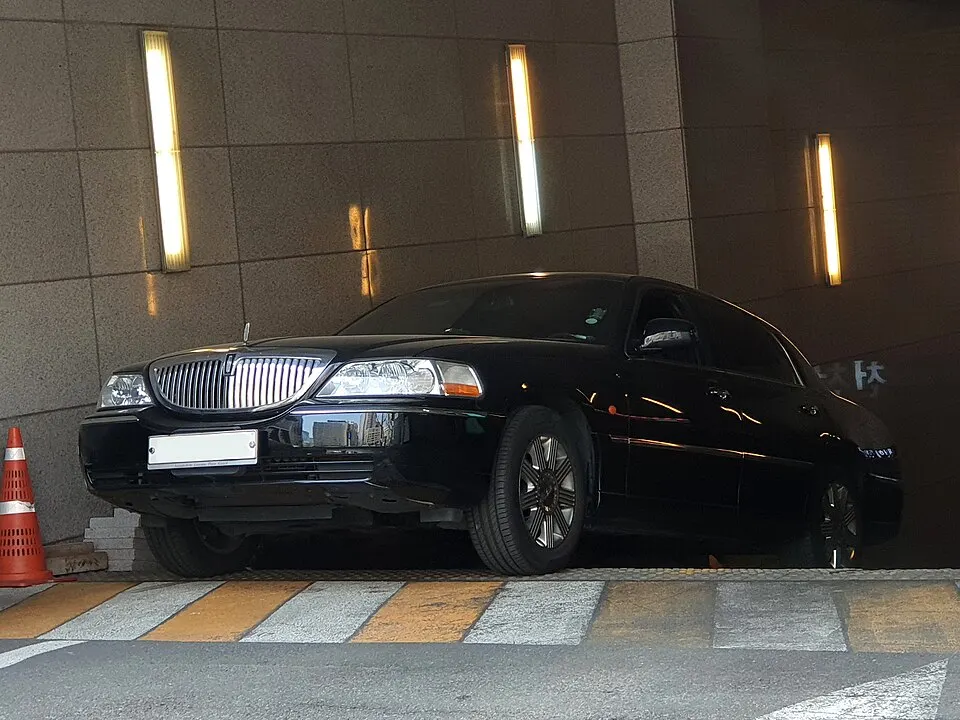 A black Lincoln Town Car parked in a garage