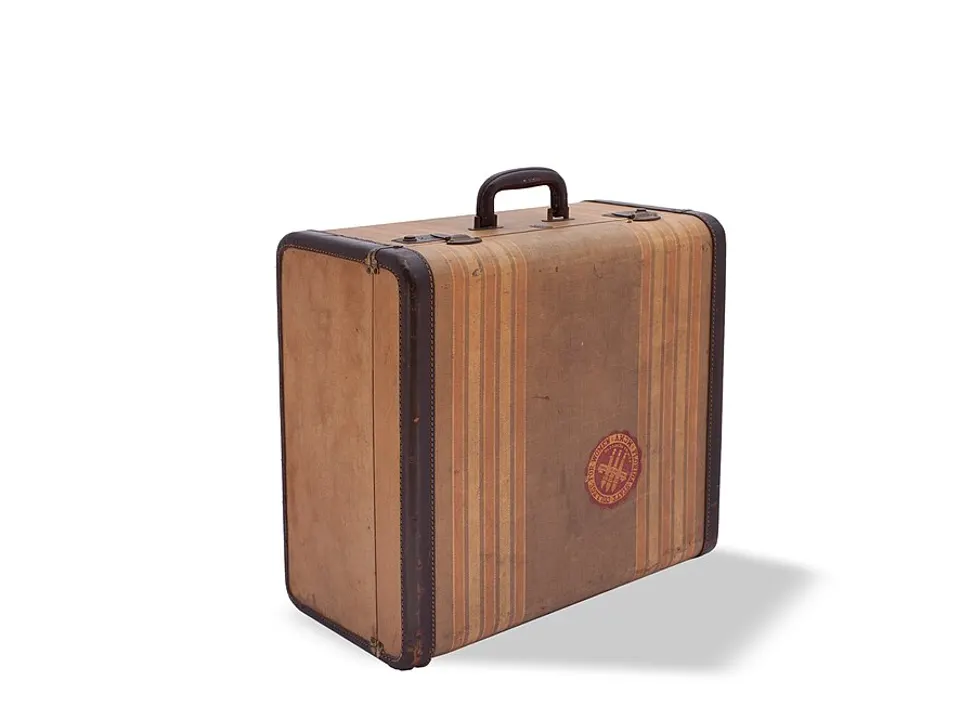 A brown striped suitcase standing on a white floor