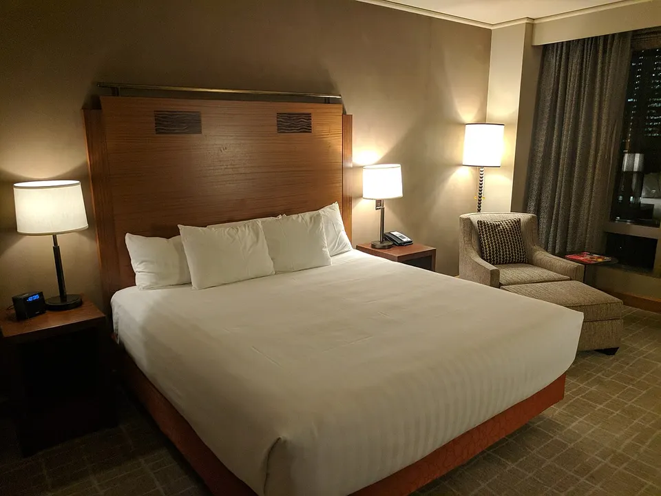 A made-up double bed in a hotel room