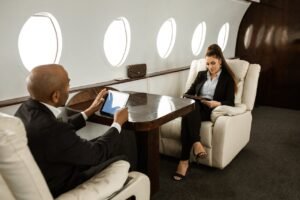 a man and woman sitting in chairs in a plane